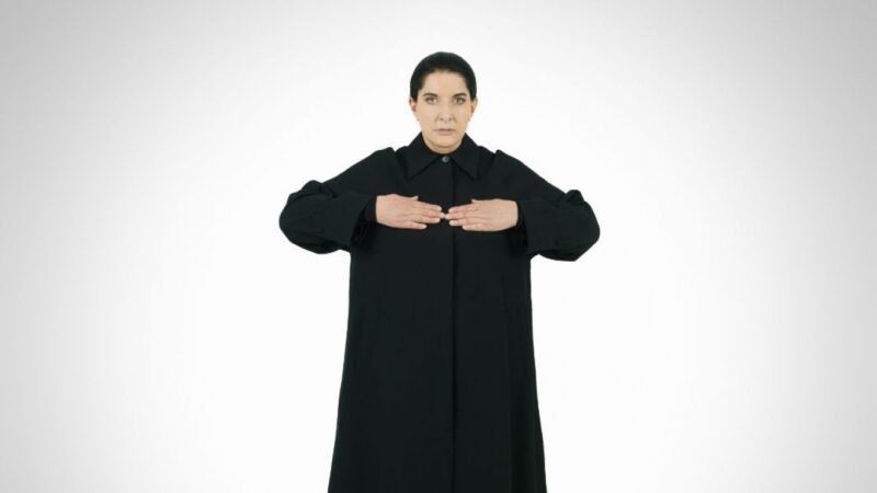 Marina Abramovic with her hands up and her fingers touching