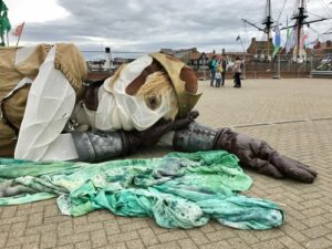The Giant Bran giant puppet lying down near the Hartlepool waterfront