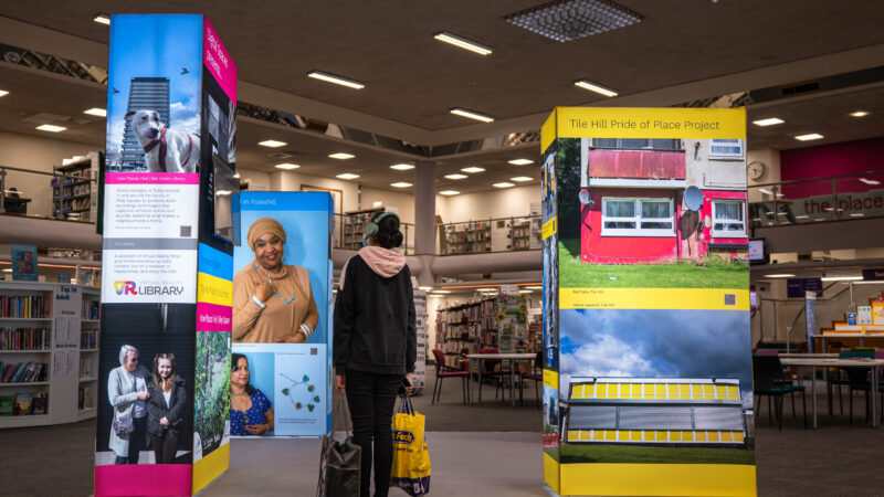 A woman in a library looks at digital display screens