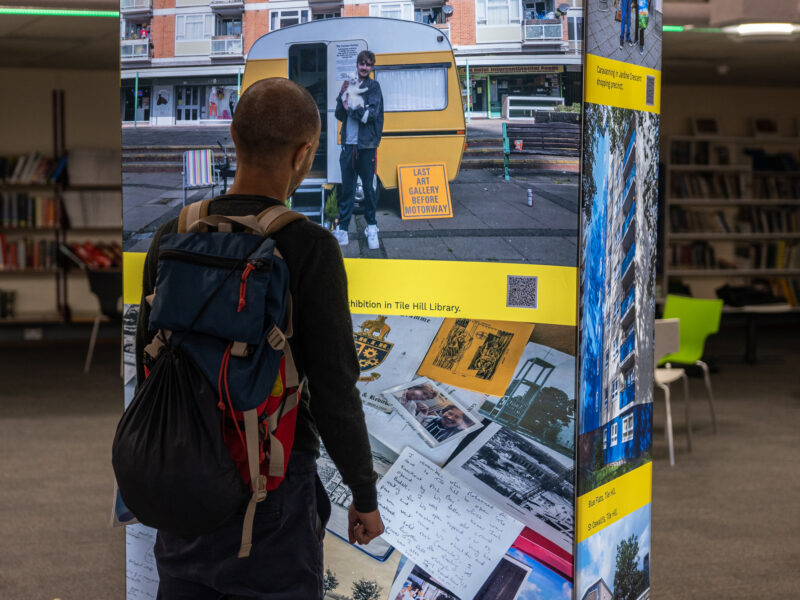 A man looks at a digital display screen in a library