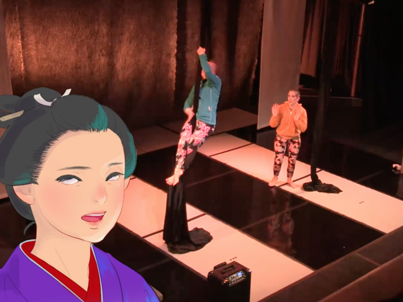 An animated image of a Geisha is inset into a photograph of people performing on stage