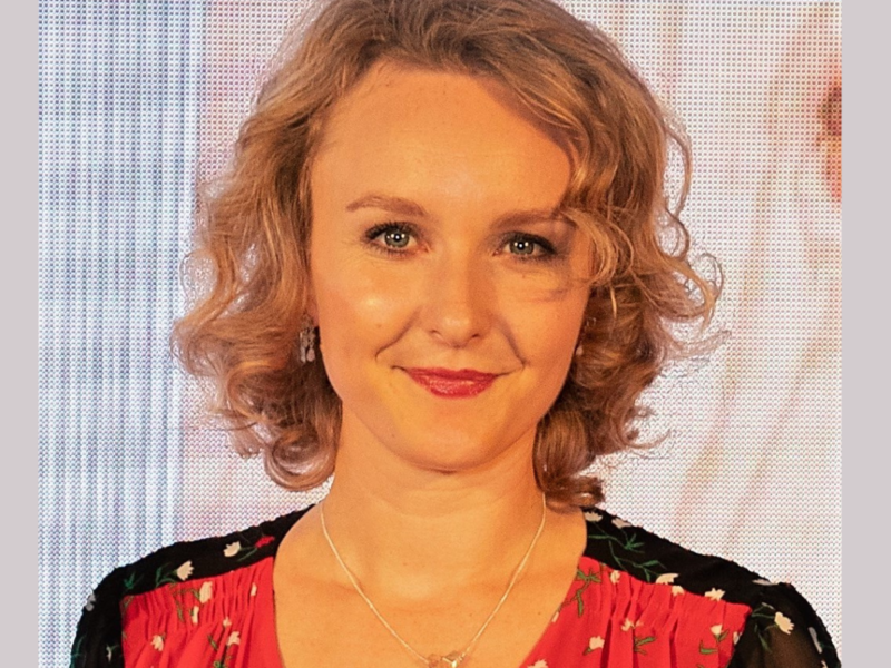 Catherine Allen. A light skinned woman with curly blond hair