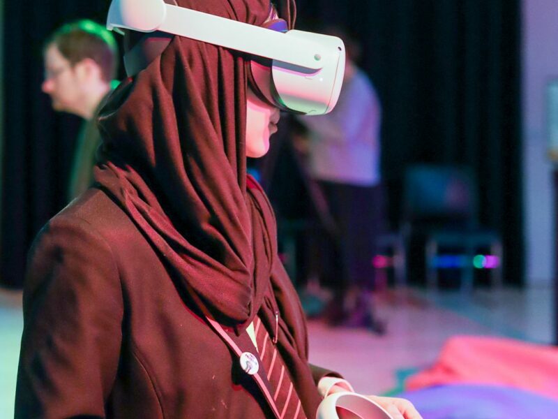 A person wearing a hijab wears a VR headset