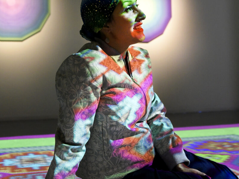 Photo of Zarah Hussain bathed in colourful lights