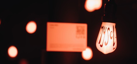 Photo of one of the lightbulbs from the exhibition, with the word 'myself' painted on it.